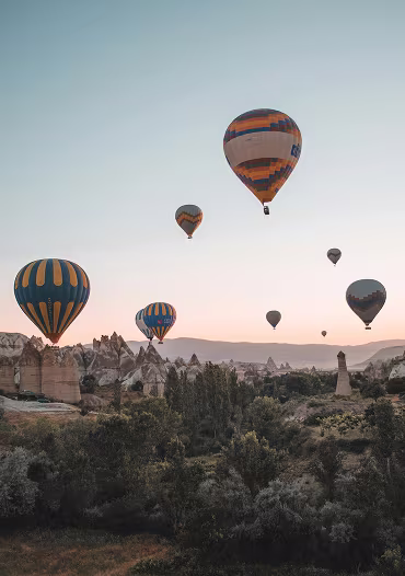 Hot air balloons over a canyon at sunrise